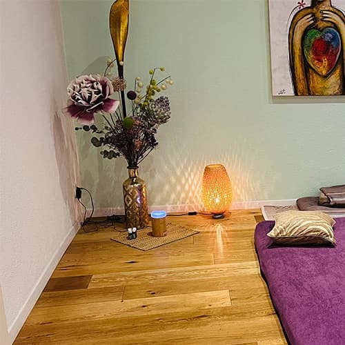 Kissen mit Klangschale und Kette auf der Massagematte der Praxis