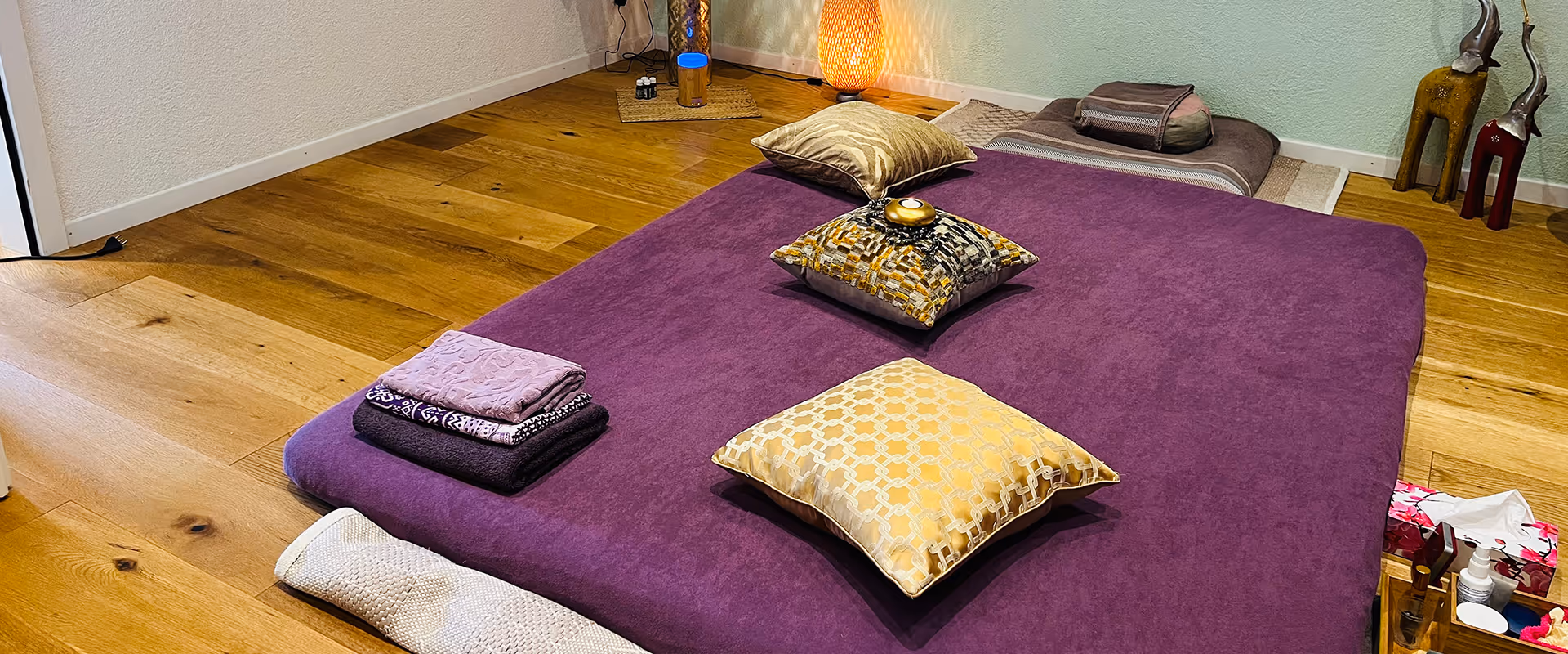 Praxisraum von Veronika Mutti in Zürich-Altstetten mit violetter Massagematte, Kissen und warmem Holzboden