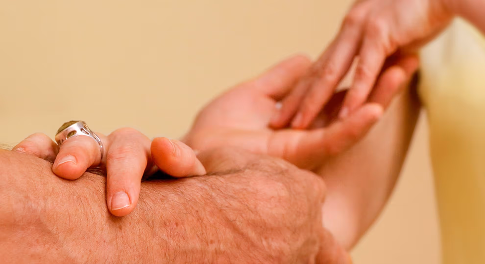 Zwei Hände, die sich sanft berühren, symbolisieren Verbindung und Fürsorge für Tantra Massage Kurs