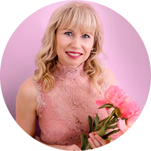 Lächelnde blonde Frau in rosa Spitzenkleid hält pinke Pfingstrosen vor rosa Hintergrund Veronika Mutti Autor