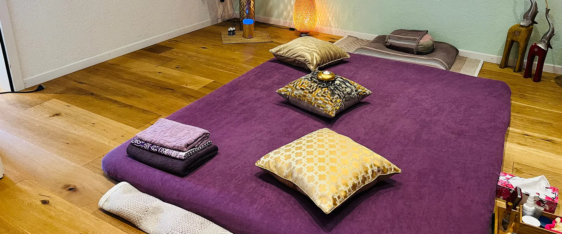 Praxisraum von Veronika Mutti in Zürich-Altstetten mit violetter Massagematte, Kissen und warmem Holzboden