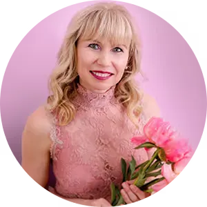 Lächelnde blonde Frau in rosa Spitzenkleid hält pinke Pfingstrosen vor rosa Hintergrund Veronika Mutti Autor